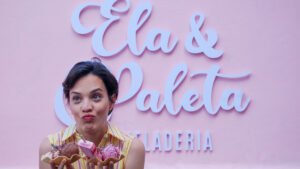 mujer con helados en las manos delante del logo de ela & paleta