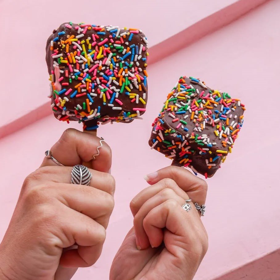 manos alzando chocogalletas de helado